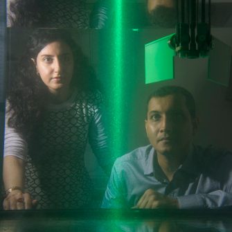 Dr Soudeh Mazharmanesh and Dr Sridhar Ravi from the University of NSW Canberra watch illuminated particles flow through a tank while testing a wing shape. The researchers work examines how insects can give insights into drone engineering.